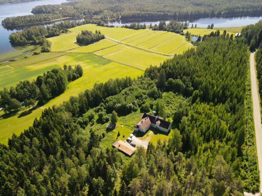 The main house with fields and the lake behind